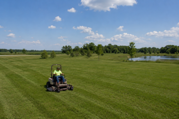 Commercial mower creating clean mowing patterns on a large open lawn