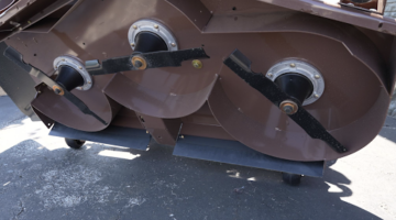 Grasshopper front-mounted mower deck flipped over for blade and underside inspection during maintenance.